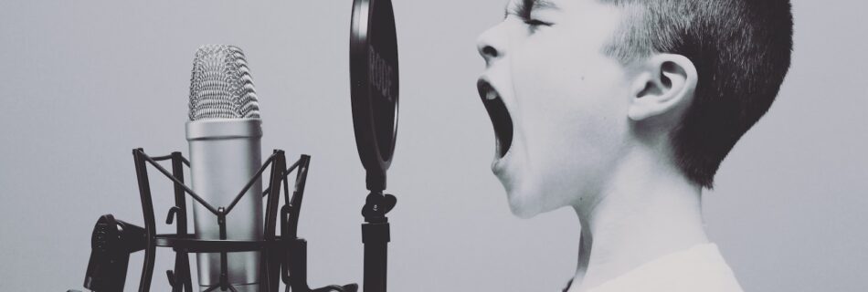 boy singing on microphone with pop filter