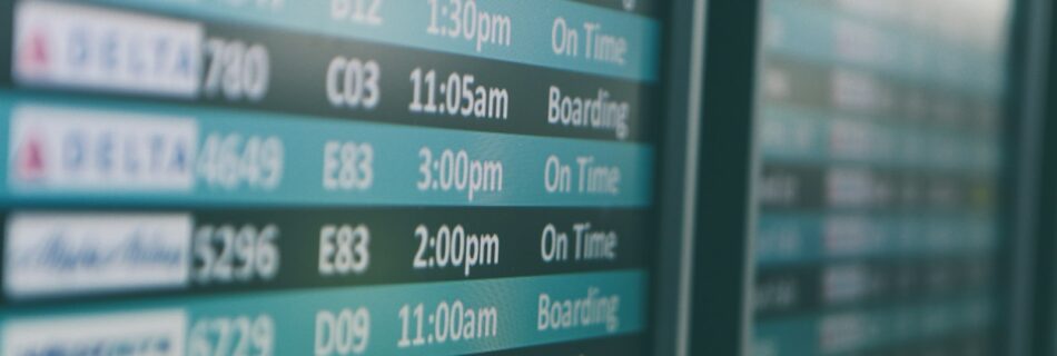 Airport departures timetable showing Delta and Alaska Airlines flights on time and boarding