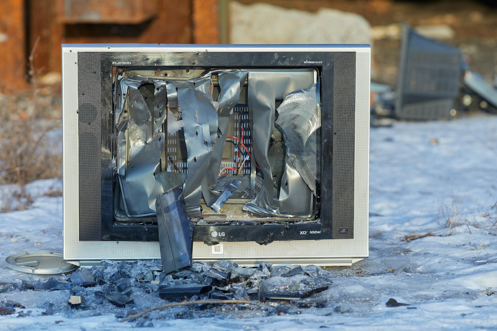 a broken television sitting on top of snow covered ground