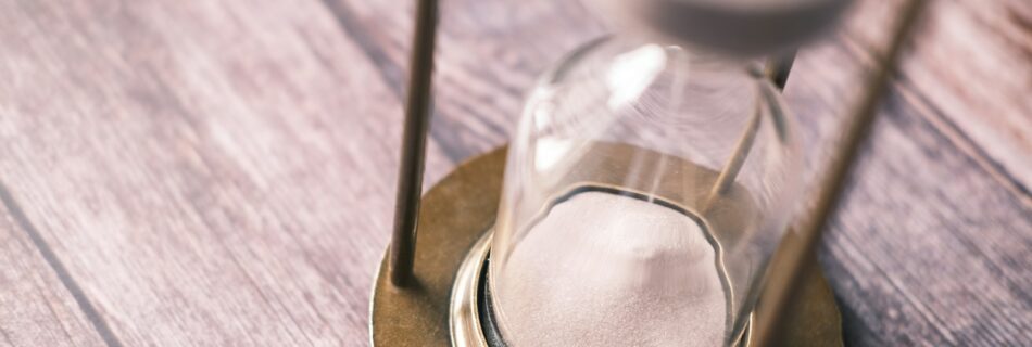 an hourglass sitting on top of a wooden table